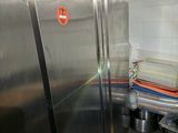 a large stainless steel refrigerator in a kitchen with a lot of dishes on the counter