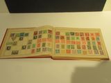 an open book with stamps on it sitting on a table