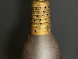 a brown vase sitting on a table in front of a gray wall