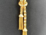 a gold necklace with a tassel on a mannequin mannequin