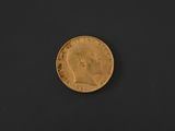 a close up of a gold coin on a black surface