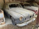 deux vieilles voitures garées dans un garage