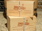 three wooden boxes stacked on top of each other in front of a barrel of wine