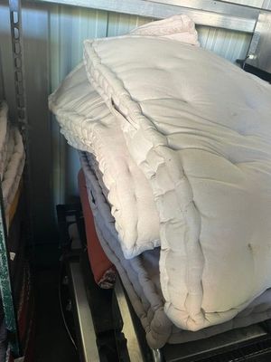 a stack of pillows and blankets on a shelf in a room