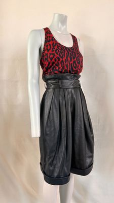 a mannequin wearing a red and black top and black leather skirt
