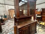 a wooden cabinet with a glass door in the middle of a room