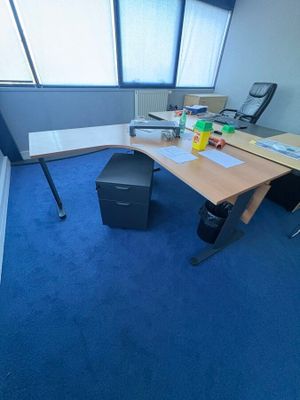 une photo d'un bureau avec de la moquette bleue et un bureau