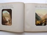 an open book with pictures of mountains and a river in it