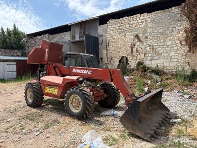 a red tractor that is parked in front of a building