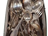 a box full of silver spoons and forks in it