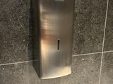 a stainless steel toilet paper dispenser mounted to the wall