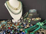 many different colored beads and necklaces displayed on a table