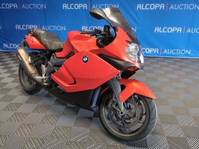 une moto rouge garée devant un fond bleu