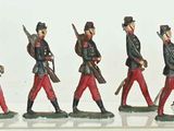 many figurines of men in uniform standing next to a cannon