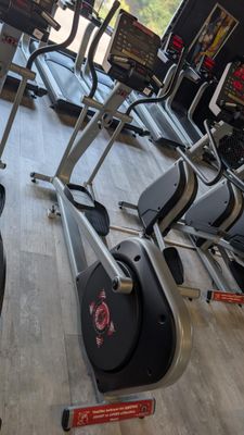 a row of stationary exercise bikes in a gym