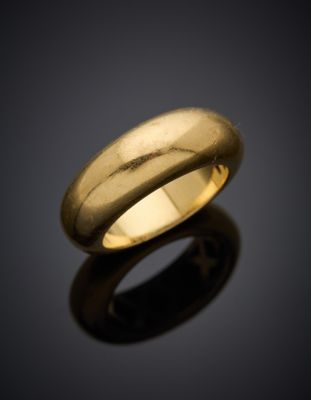 gros plan d'une bague en or sur une surface noire