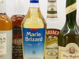 bottles of various types of alcohol are lined up on a white surface