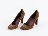 une paire de chaussures à talons hauts en daim marron sur fond blanc