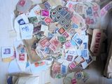 une pile de timbres posée sur une table, à côté d'une paire de ciseaux