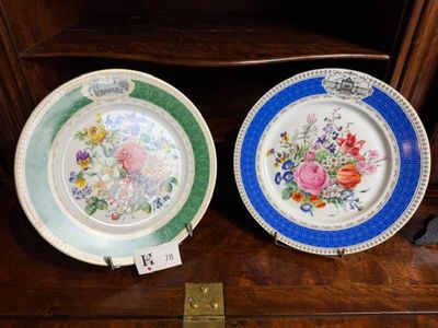deux assiettes ornées de fleurs, posées sur une étagère