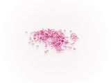 a pile of pink crystals sitting on top of a white surface