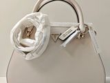 a white purse with a white flower on the handle