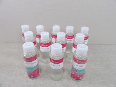 Plusieurs flacons de gel hydroalcoolique sont alignés sur une table