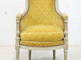 a yellow upholstered chair in a white room with a white wall