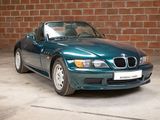 a blue bmw sports car parked in front of a brick wall
