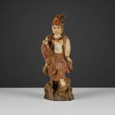a carved figurine of a man sitting on a tree stump