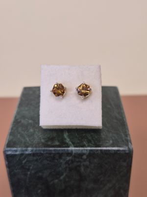 un gros plan sur une paire de boucles d'oreilles posées sur un bloc de marbre