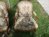 two chairs that are sitting in the grass near a tree