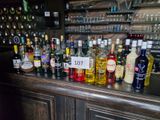 bottles of alcohol are lined up on a bar counter in a bar
