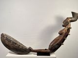une sculpture en bois représentant un homme jouant d'un instrument de musique