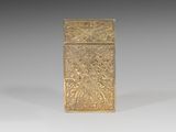 an old gold cigarette case sitting on top of a white surface