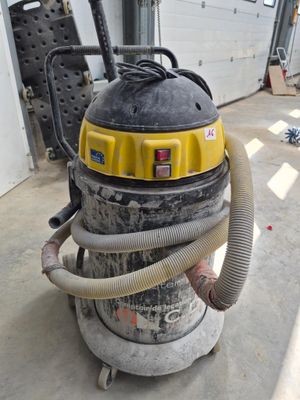 a yellow and black vacuum sitting in a garage