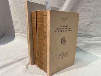trois livres sont empilés sur une surface blanche