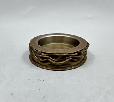 gros plan d'une bague en or sur une surface blanche