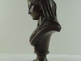 statue of a woman with a veil on her head sitting on a table