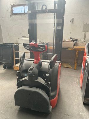 un chariot élévateur dans un entrepôt, avec d'autres équipements en arrière-plan