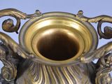 a gold vase sitting on a table with a blue background