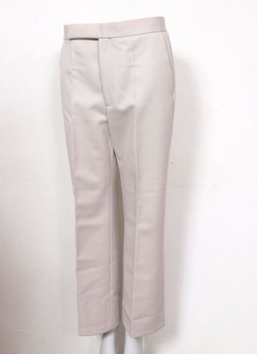 le mannequin porte un pantalon beige et une chemise blanche