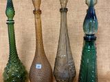 cinq vases en verre de couleurs différentes posés sur une table