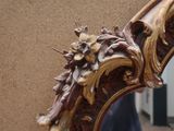 a mirror that has a decorative design on the side of it