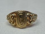 gros plan d'une bague en or sur une surface blanche
