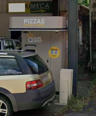a car that is parked in front of a pizza shop