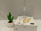 a box with a wine glass on it next to a cactus