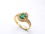 a close up of a gold ring with an emerald stone and diamonds