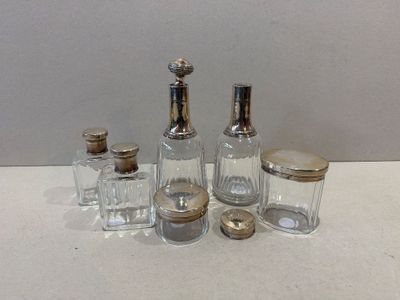 four glass bottles with silver lids sitting on a table
