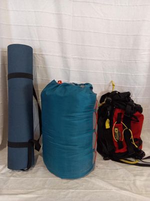 two bags and a backpack on a bed next to each other